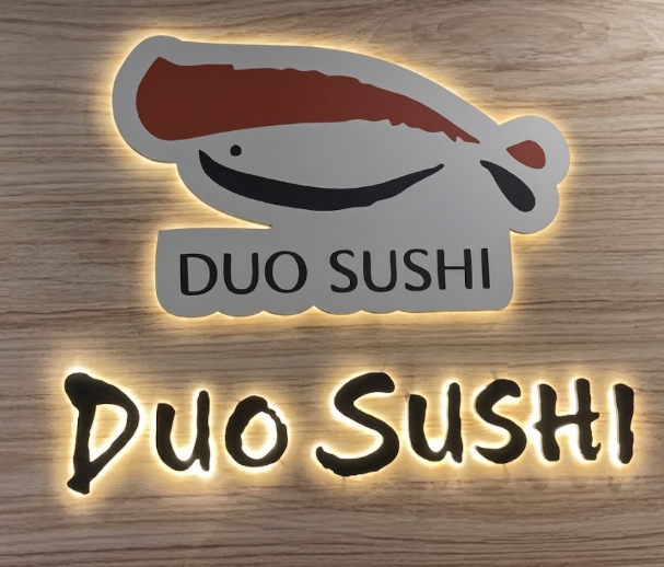 Sushi counter and chef under brass pendants